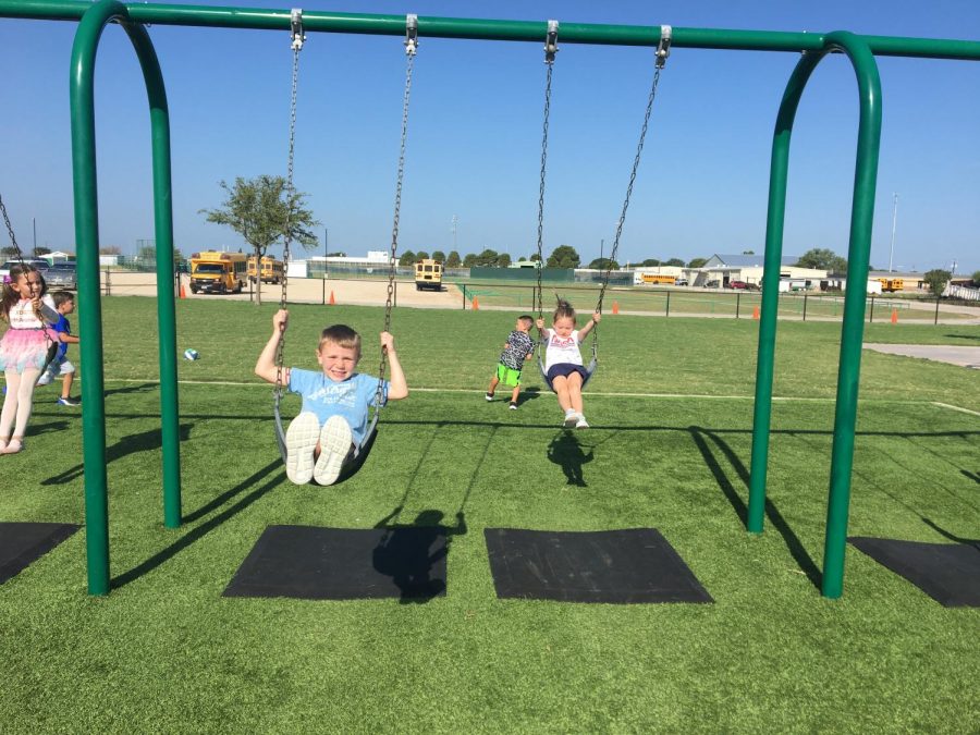 Students enjoy time on the swings during recess. 