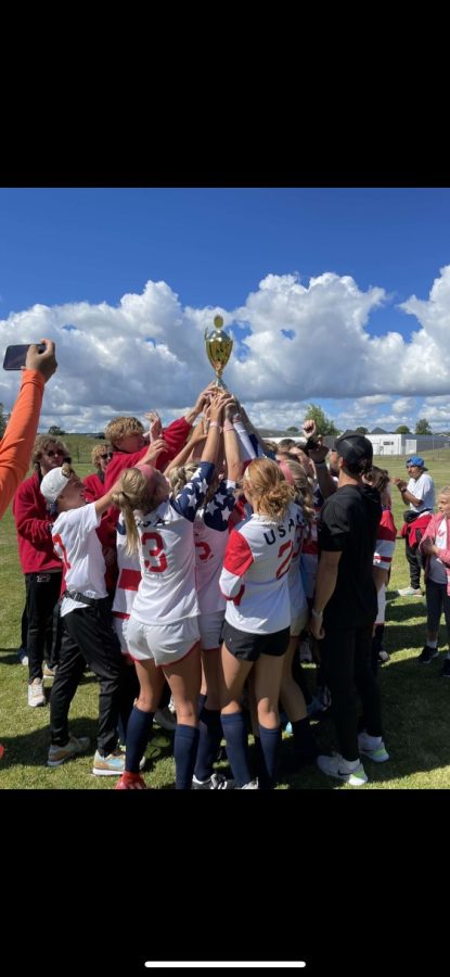 Gibbss team celebrate their first place trophy in a group huddle.